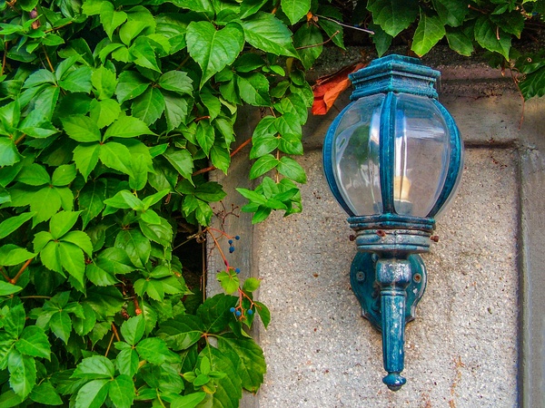 Vintage street lamp on the wall of a stone fence