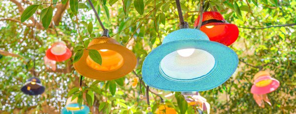 Original handmade multi-coloured lampshades hanging on tree