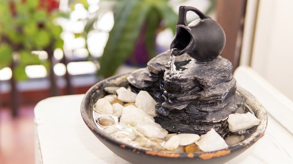 Zen water fountain near a bright balcony