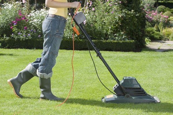 Woman Mowing Lawn with electric mower