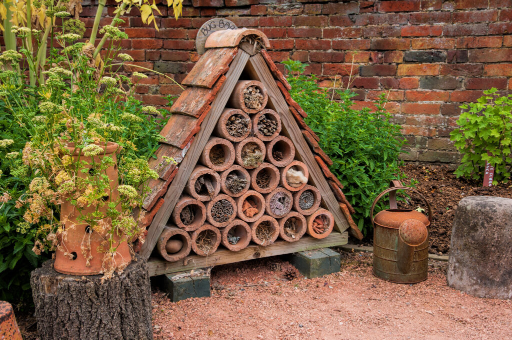 A bug or insect house made with ceramic tubes filled with material to encourage insects to breed.