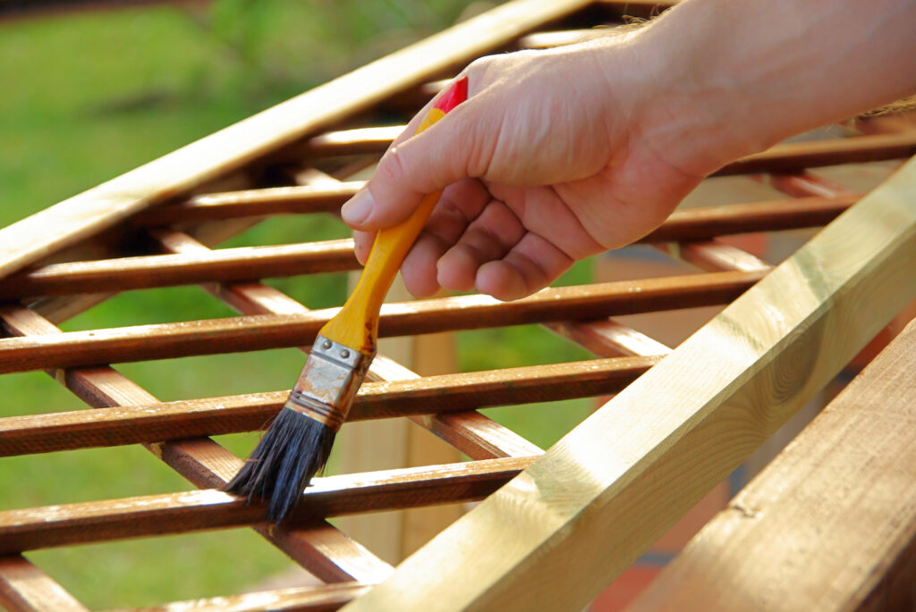 Painting a wooden trellis in the garden