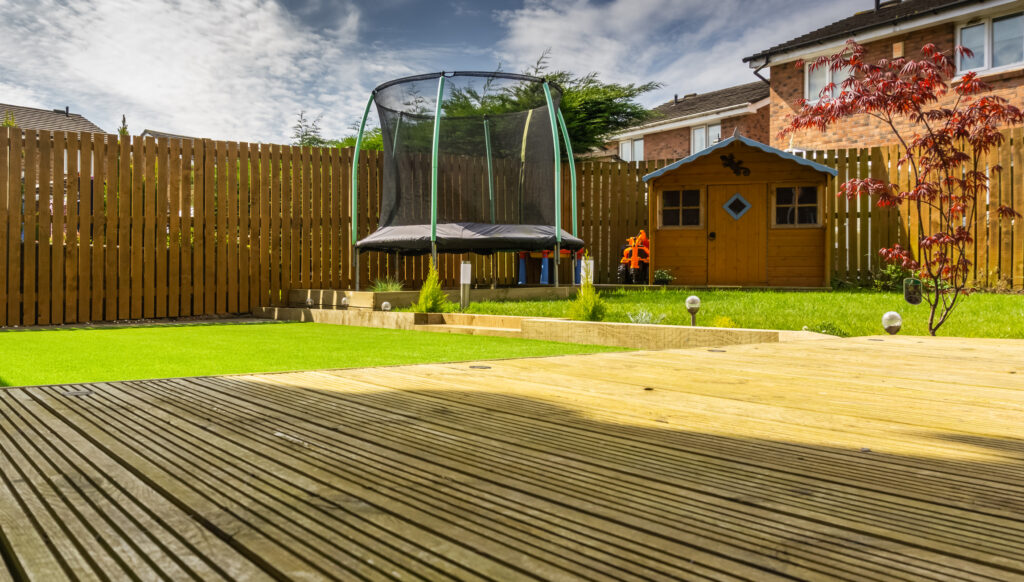 A modern garden with a new planted lawn decking shrubs and borders