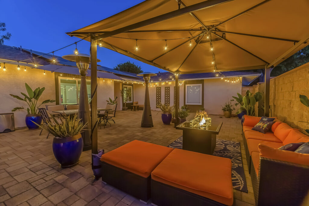 Cozy outdoor seating area under a pavilion on the patio paved with stone bricks.