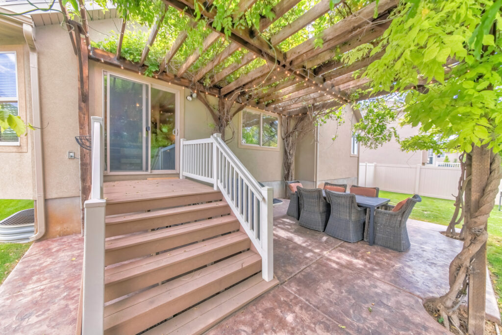 Outdoor patio with wooden pergola roof with vines and string lights