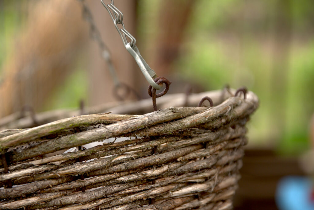 Wicker brown basket hanging on a steel chain