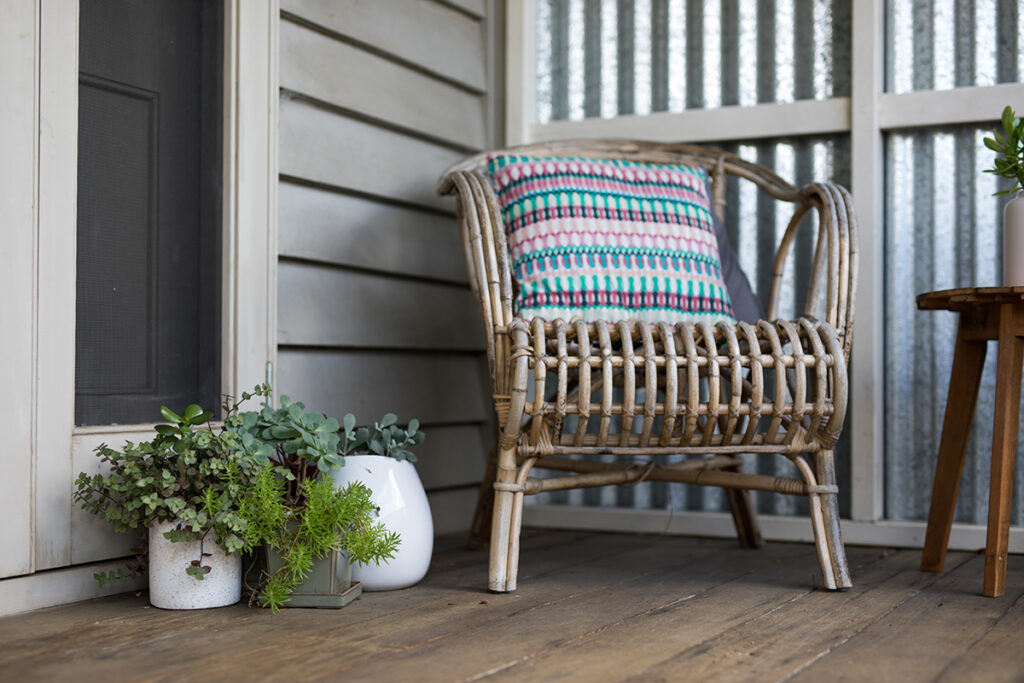 COsy wicker chair with stripey cushion on terrace in garden