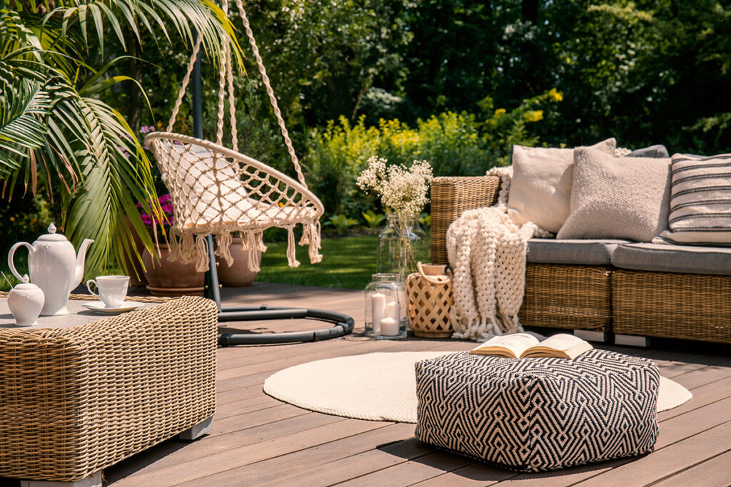 A luxury seatig area in the garden with a sofa and chair swing